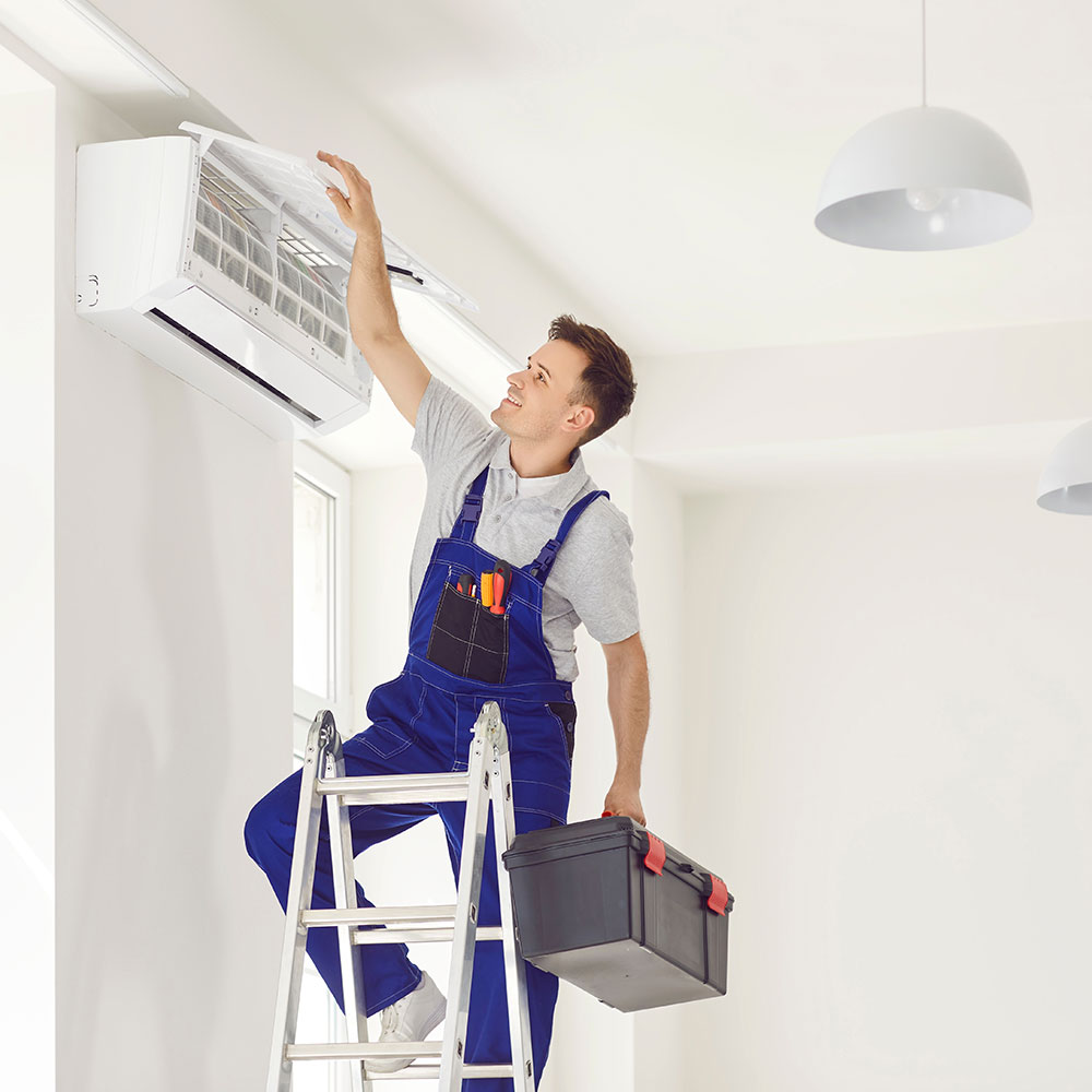 A man in uniform installing and testing an air conditioning system