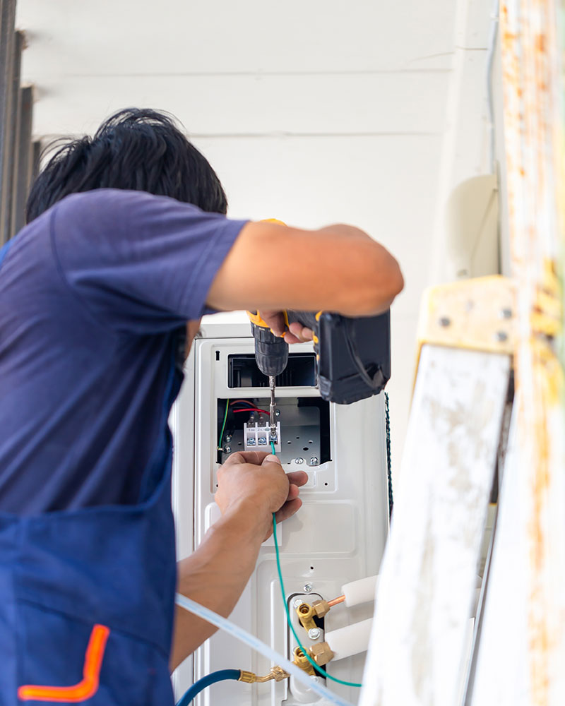 A man fitting, repairing, and configuring an air conditioning system