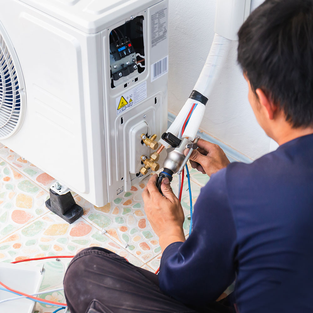 A man fitting, repairing, and configuring an air conditioning system